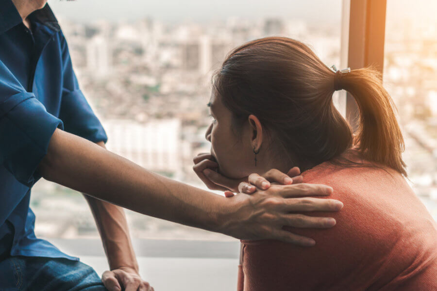 Woman being comforted by therapist after learning about the average age of mental illness