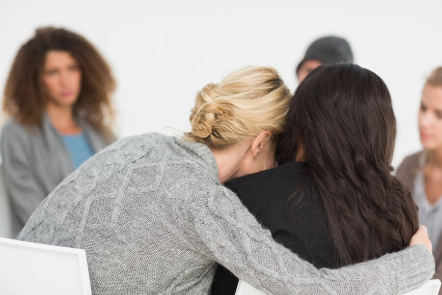 Women in rehab embracing over overdosing