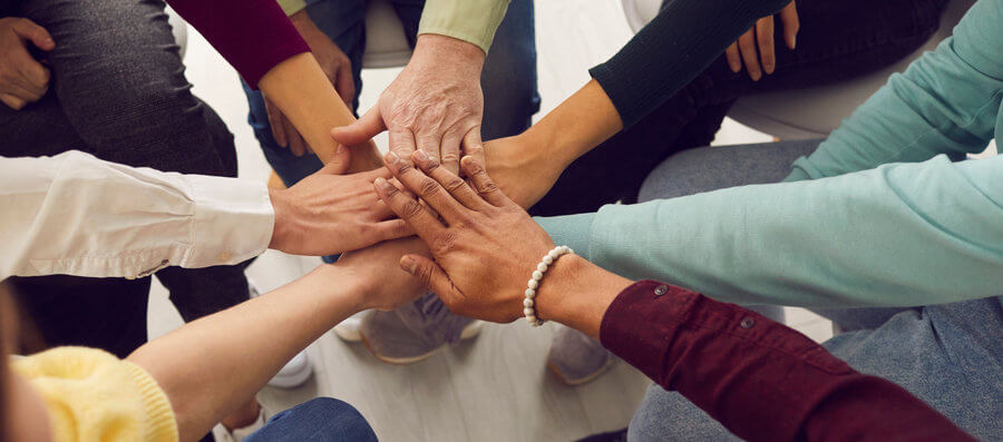 New mental health recruits putting their hands together in support