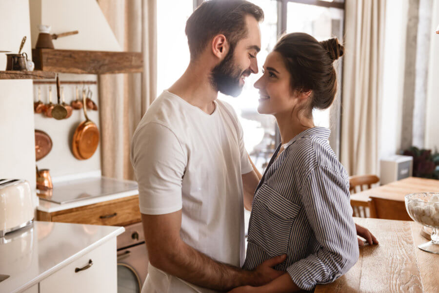 A happy couple standing in their kitchen after revitalizing their relationship