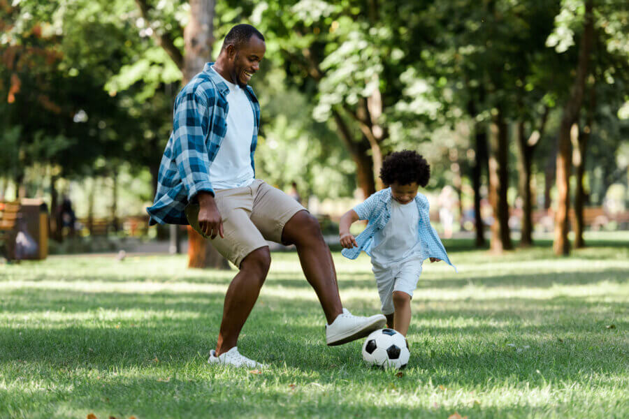 Father and son playing soccer after relief from traumatic brain injury through MeRT