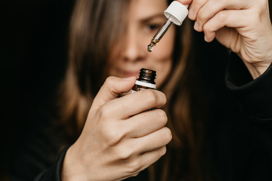 Woman dropping cbd oil from tincture