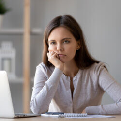 Woman sitting at computer showing signs of burnout