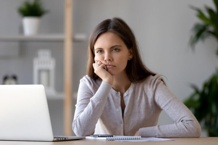 Woman sitting at computer showing signs of burnout