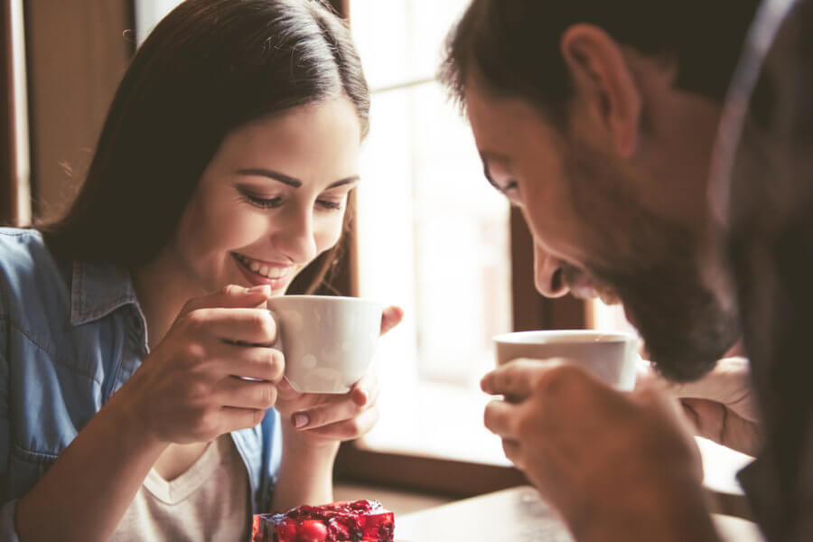 Couple smiling while drinking coffee