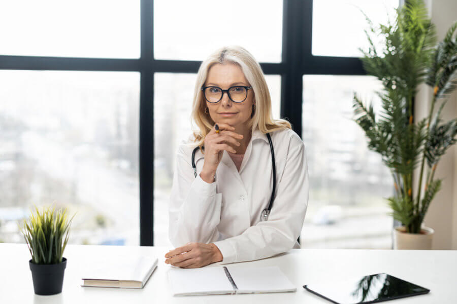 A ILADS doctor sitting at desk with plants