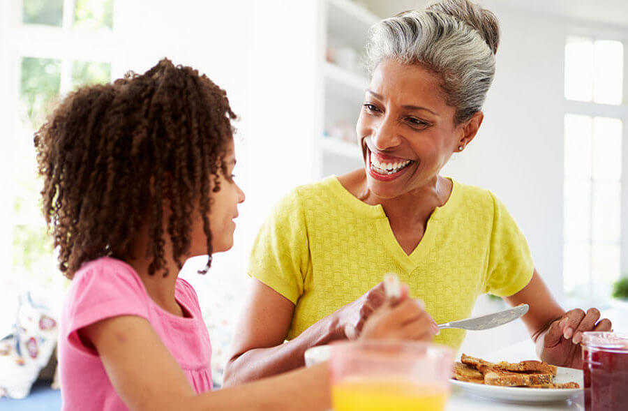 Grandmother enjoys breakfast with granddaughter while living independently in her home.